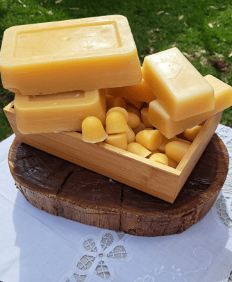 Handcrafted natural beeswax display with rustic wood, floral fabric, in outdoor setting