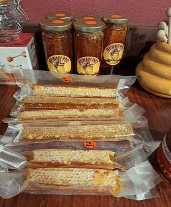 Healthy honeycomb in sealed strips and Hunny Pot raw honey jars with beehive decor