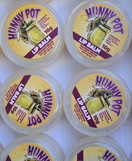 Lip balm in Hunny Pot lip balm container weighed 10 grams on white table cloth